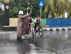Hujan Tak Halangi Polsek Gerung Atur Lalu Lintas Sekolah